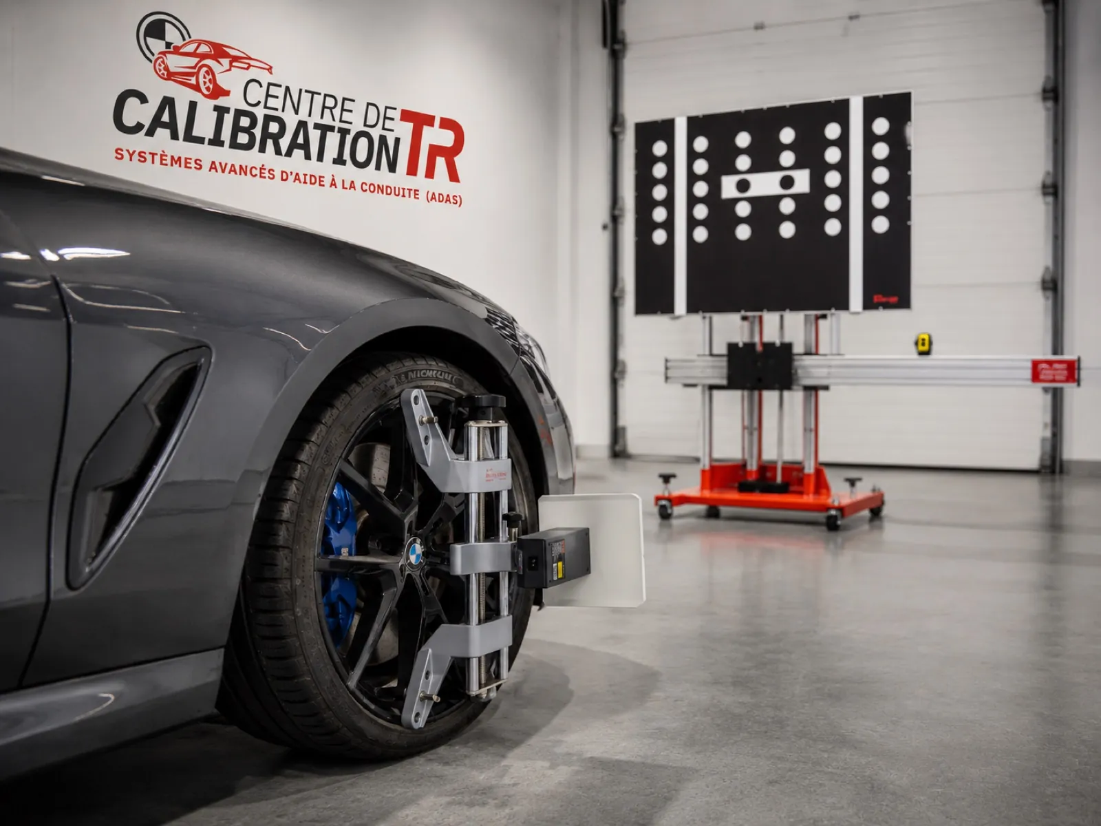 Équipement de calibration fixé à une roue BMW avec cible ADAS en arrière-plan